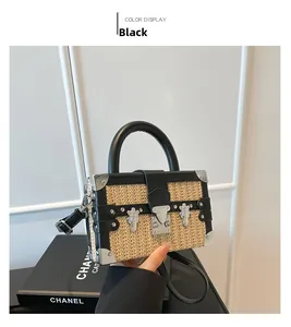Detail of a woven box bag with black leather trim, metal corner studs, and buckle system