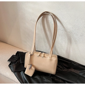 Detail of apricot baguette shoulder bag with double straps and small detachable pouch