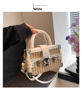Detail of white woven straw box bag featuring silver metal corners and retro buckle clasp