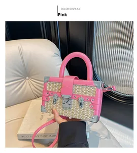 Detail view of a pink leather and straw box bag featuring vintage silver metal hardware