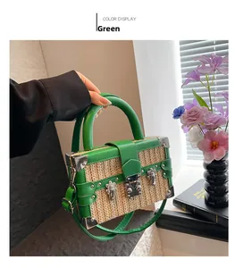Close-up of green woven straw box bag with silver metal corners and classic twist lock