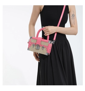 Detail showing pink leather straw weave box bag with silver corner guards and rivets