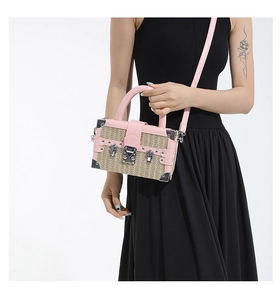 Detail of pink leather trim and woven straw texture on a vintage box crossbody bag