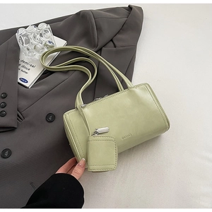 Close-up of minimalist mint green baguette bag with detachable coin purse and silver hardware