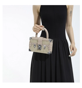 Detailed view of straw-woven box bag with beige leather trim and silver metal hardware