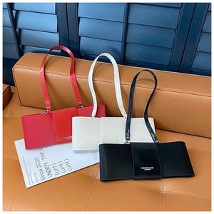 Detailed view of french style baguette bags in red, white and black colors on sofa