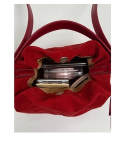 Vista interna di una borsa a secchiello in camoscio rosso con chiusura magnetica