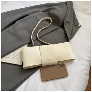 Detail of off-white bow-knot shoulder bag with embossed fashion text on high-quality leather