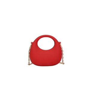 Minimalist red acrylic top-handle handbag with modern cutout design and golden metal chain