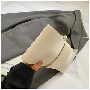 Minimalist beige baguette bag with smooth matte leather texture and silver buckle detail