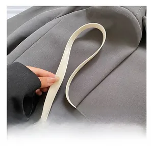 Detail of off-white PU leather strap with silver buckle on a minimalist shoulder bag