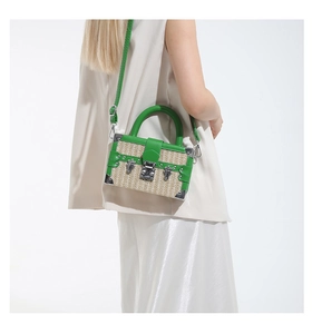 Detail of green leather and straw woven box bag with silver lock and top handle