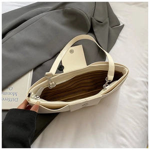 Detail view of the white leather bag interior featuring striped lining and a smooth zipper