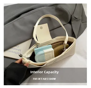 Detail view showing the large internal capacity of the creamy white baguette bag