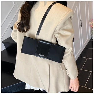 Detail of black leather underarm bag featuring fashion text strap and slim shoulder belt
