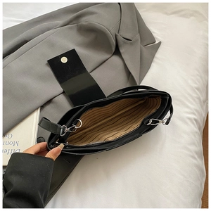 Black leather underarm shoulder bag with striped lining and silver metal zipper