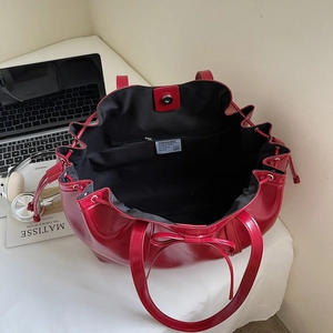 Minimalist red glossy patent leather tote bag with drawstring and bow detail