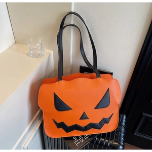 Detailansicht der orangefarbenen Halloween-Tragetasche aus Leder mit Kürbisgesicht