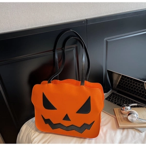 Detailaufnahme der orangefarbenen Kürbis-Einkaufstasche mit schwarzer Jack-O-Lantern-Stickerei