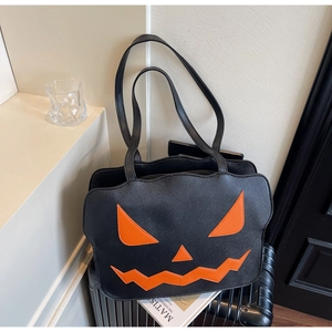Detailansicht der Halloween-Tasche aus schwarzem Leder mit orangefarbenem Kürbisgesicht-Stick