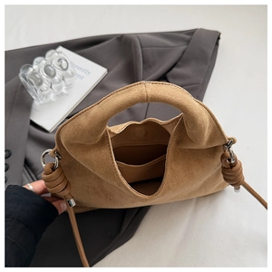 Close-up of the suede texture and sturdy magnetic buckle closure on this brown bag
