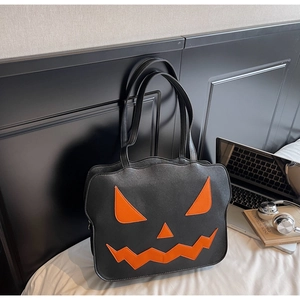 Detail einer Halloween-Einkaufstasche aus schwarzem Kunstleder mit orangefarbenem Kürbisgesicht