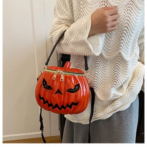 Detail showing the orange pumpkin bag texture with black eyes and gold hardware