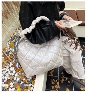 Detail of a beige quilted puffer tote and a black ruched handbag for autumn