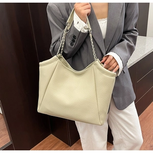 Gros plan détaillé du grand sac cabas beige avec texture litchi et bandoulière chaîne