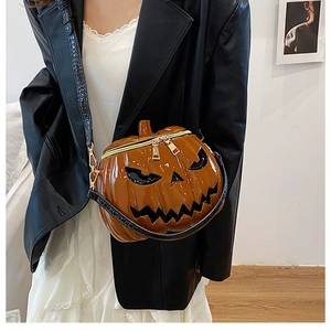 Detail of pumpkin crossbody bag featuring dual zippers and black crocodile texture strap
