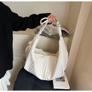 Detail view of white ruched nylon dumpling bag showing pleated texture and silver buckle