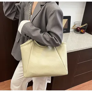 Vue détaillée du sac cabas en cuir blanc cassé avec chaîne argentée sur un modèle