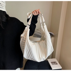 Detail of white pleated nylon dumpling bag showing refined texture and silver metal buckle