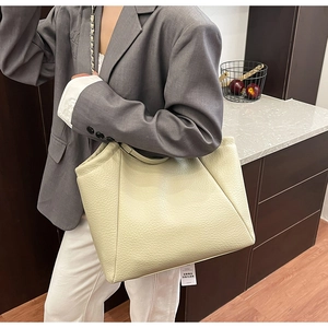 Détail de la texture cuir crème grainé sur un grand sac cabas avec bandoulière