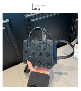 Détail du sac bandoulière en cuir noir avec ornements de rivets de style punk rock
