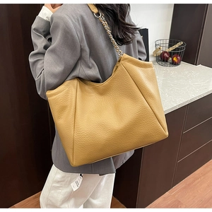Détail du sac cabas jaune gingembre en cuir grainé avec bandoulière en chaîne argentée