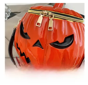Close-up of vibrant orange pumpkin shoulder bag with dual gold zippers and glossy texture