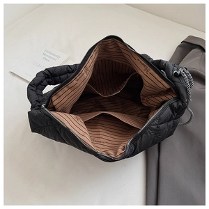 Interior detail of quilted tote bag featuring striped lining and multiple storage pockets
