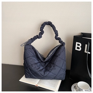 Close-up of quilted nylon tote bag with scrunchie handle in a stylish lifestyle setting
