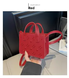 Vue détaillée du mini sac bandoulière rouge en cuir texturé avec motifs de rivets