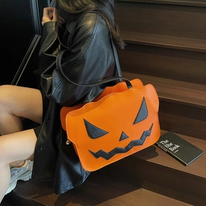 Leuchtend orangefarbene Handtasche in Kürbisform mit Gruselgesicht für Halloween