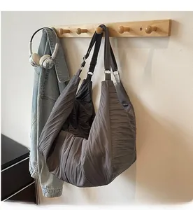 Detail of dark grey pleated shoulder bag showing premium nylon texture and ruching