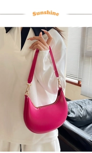 Detail of fuchsia crescent hobo bag in smooth leather with gold metal zipper and strap ring