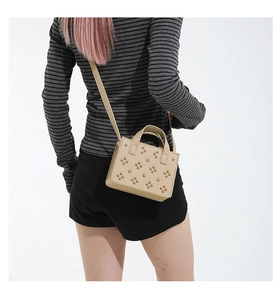 Détails du sac bandoulière beige avec rivets floraux 3D et structure carrée rigide élégante