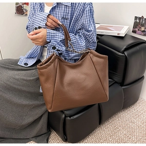 Gros plan du sac cabas marron en cuir avec bandoulière chaîne et design spacieux