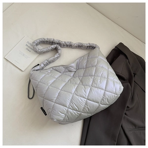 Close-up of silver quilted tote bag with large diamond stitching and scrunchie style strap