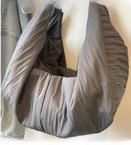 Detail of the deep gray nylon dumpling bag showing fine vertical pleated fabric texture