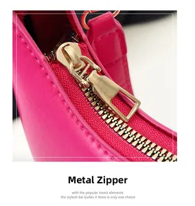 Close-up of premium gold zipper hardware on hot pink leather crescent bag detail