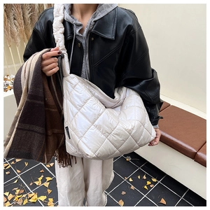 Detail of off-white quilted puffer tote bag featuring classic diamond stitching pattern
