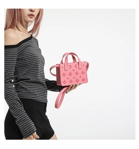Détail du mini sac cabas rose à clous en cuir texturé avec bandoulière réglable